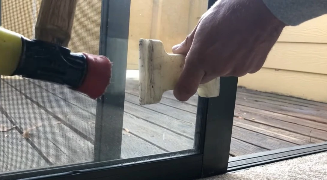 Technician removing a sliding glass door panel for glass replacement in Fort Myers FL