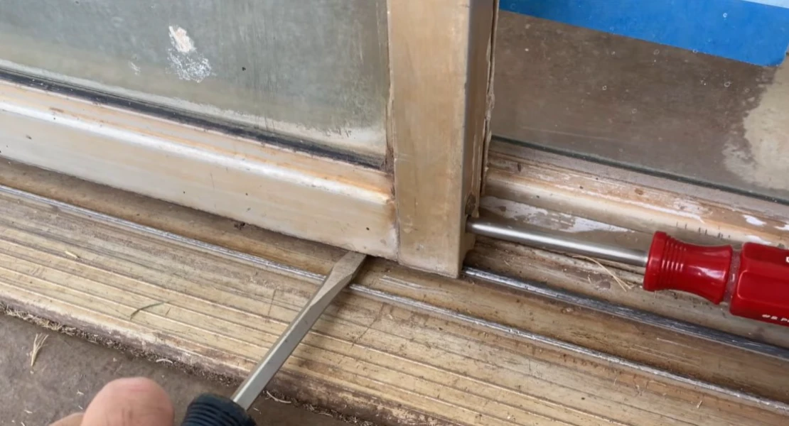 Sliding door track adjustment being performed to fix a sticking or hard-to-open door